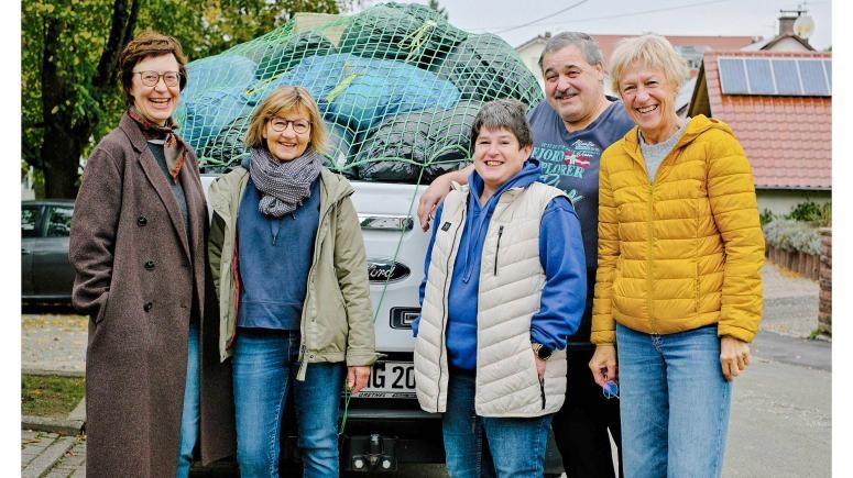 Helfer Kleidertausch vor Pickup mit Kleidung geladen