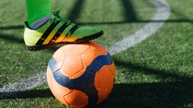 Fuß steht auf Fußball