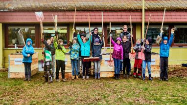 Kinder die Besen hochhalten